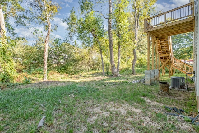 view of yard with central AC, a deck, and stairs