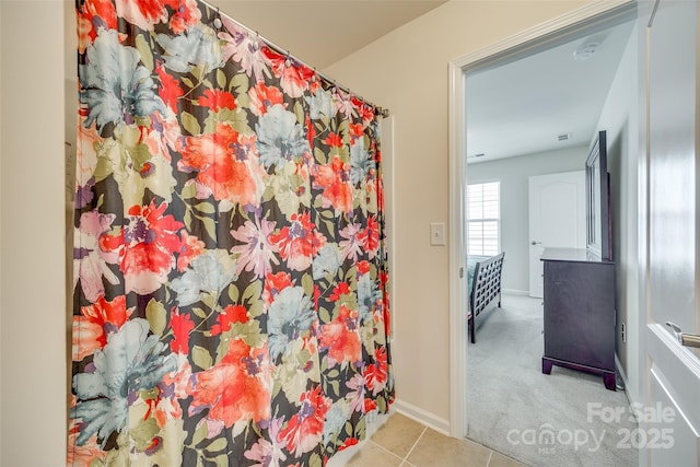 full bath with curtained shower, baseboards, and tile patterned floors