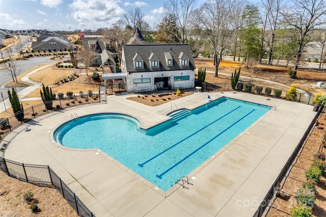 community pool with fence and a patio