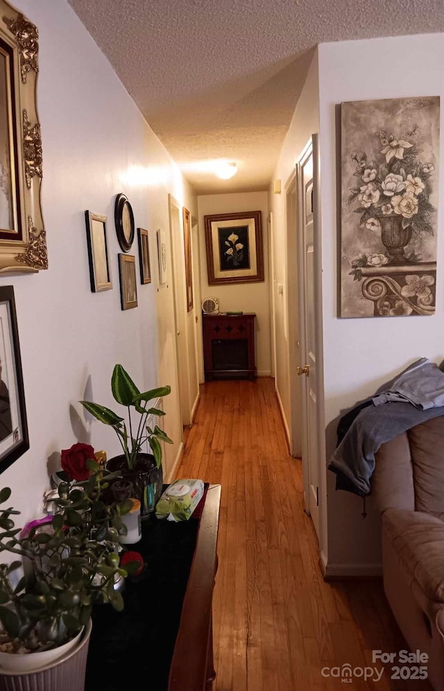 hallway featuring a textured ceiling and light wood-type flooring