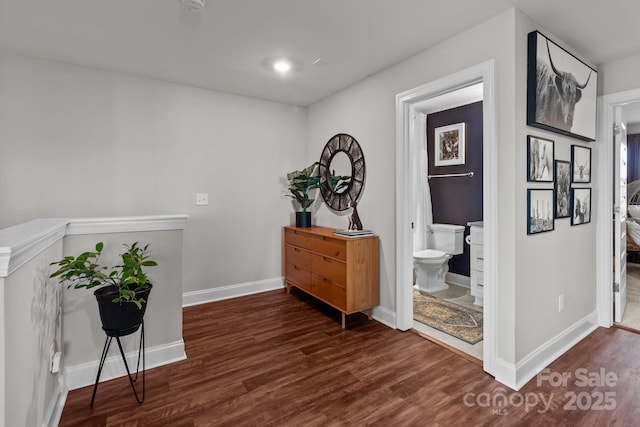 hallway featuring dark wood-style floors and baseboards