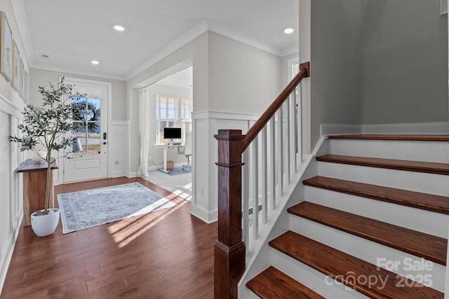 foyer with recessed lighting, a wainscoted wall, wood finished floors, stairway, and crown molding