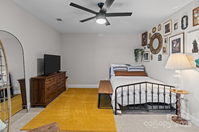 bedroom featuring light carpet, baseboards, visible vents, and a ceiling fan