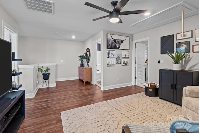 living room with baseboards, attic access, visible vents, and dark wood-style flooring