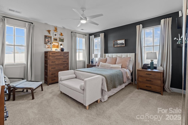 bedroom featuring light carpet, baseboards, visible vents, and a ceiling fan