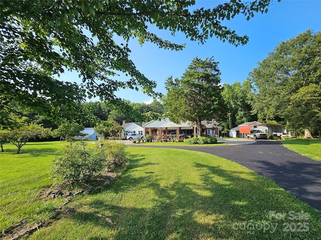 view of front of property featuring driveway and a front lawn