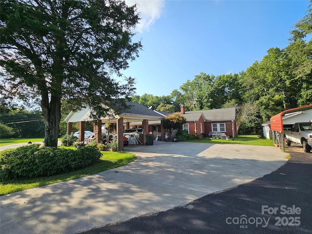 view of front of home with a chimney, a front lawn, and brick siding