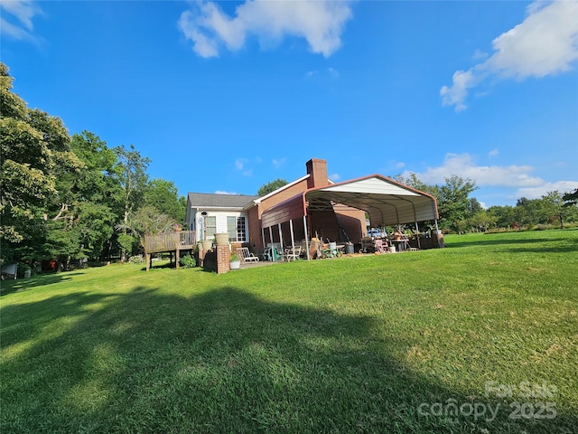 rear view of property with a chimney, a deck, and a lawn