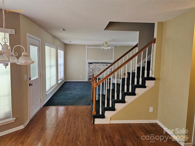 foyer featuring stairs, dark wood finished floors, visible vents, and baseboards