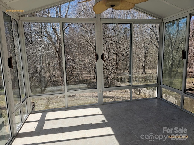 unfurnished sunroom featuring ceiling fan and vaulted ceiling