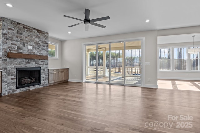 unfurnished living room featuring ceiling fan, recessed lighting, a fireplace, and wood finished floors