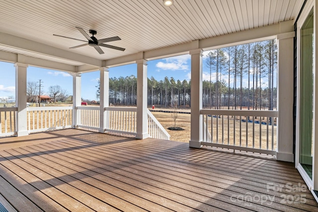 unfurnished sunroom featuring ceiling fan and plenty of natural light