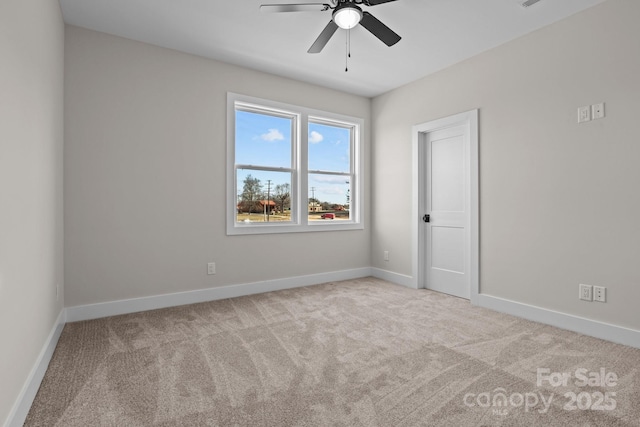 empty room with a ceiling fan, light colored carpet, and baseboards