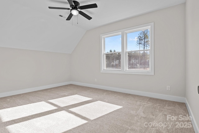 bonus room with lofted ceiling, light colored carpet, visible vents, a ceiling fan, and baseboards