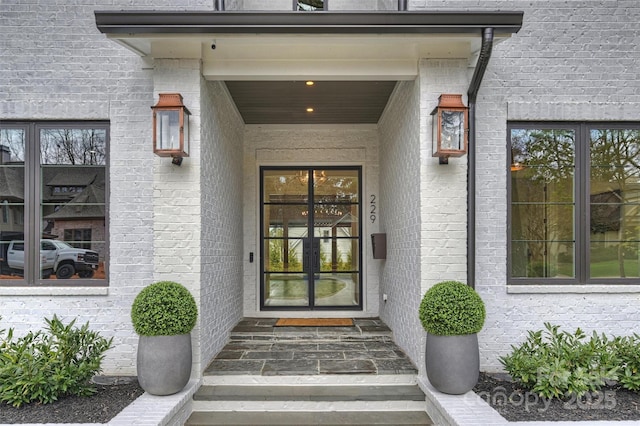 view of exterior entry featuring brick siding