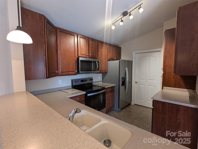 kitchen featuring a sink, pendant lighting, stainless steel appliances, and light countertops