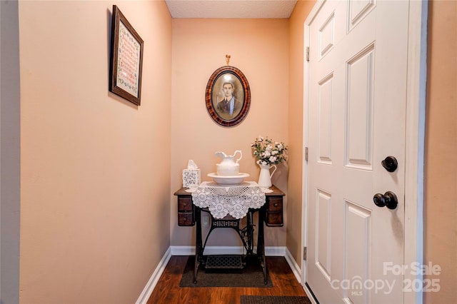 doorway with dark wood-style floors and baseboards