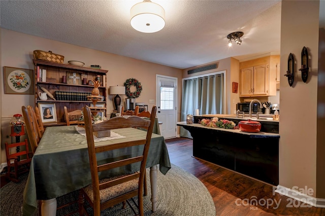 dining room featuring dark wood finished floors and a textured ceiling