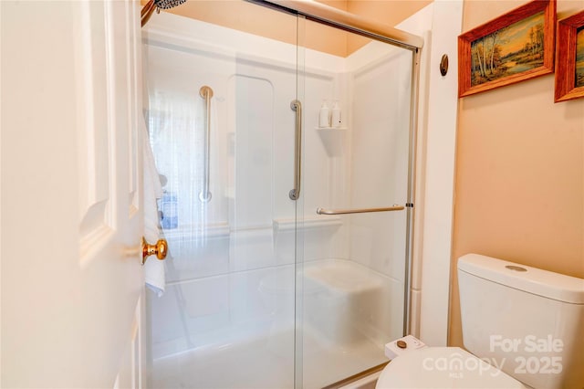 full bathroom with a shower with door and toilet