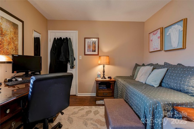 bedroom with a closet, baseboards, and wood finished floors