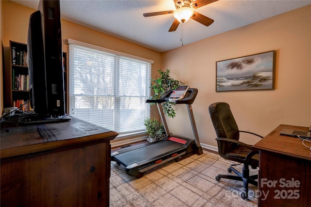 office area featuring a textured ceiling, baseboards, and a ceiling fan