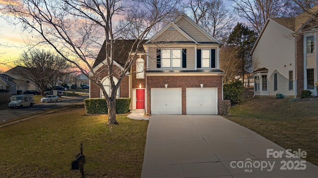 traditional home featuring a yard, brick siding, driveway, and an attached garage