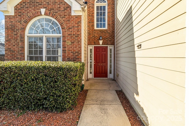 doorway to property featuring brick siding