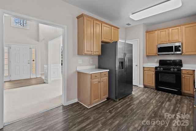 kitchen featuring dark wood-style flooring, stainless steel appliances, light countertops, light brown cabinets, and baseboards