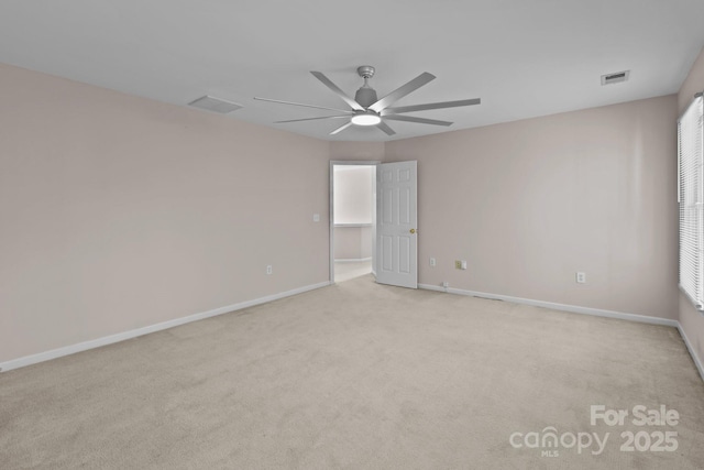 carpeted empty room featuring ceiling fan, visible vents, and baseboards