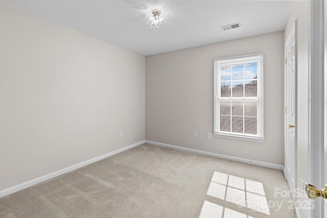 empty room featuring baseboards, visible vents, and light colored carpet