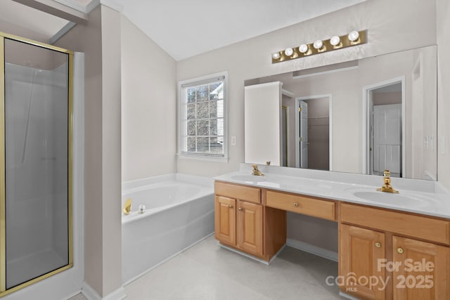 full bathroom featuring a stall shower, double vanity, a sink, and a bath