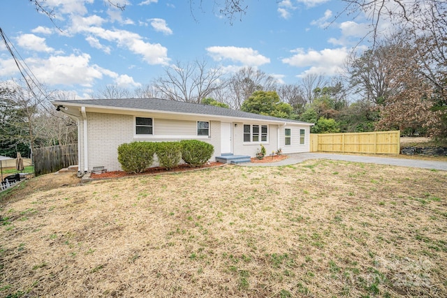 single story home with brick siding, a front yard, and fence