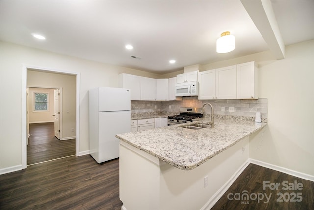 kitchen featuring white appliances, visible vents, a peninsula, and decorative backsplash