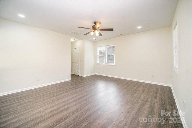 unfurnished room featuring dark wood-style floors, ceiling fan, and baseboards