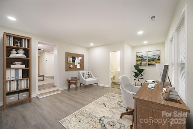 office space with recessed lighting, visible vents, light wood-style flooring, and baseboards