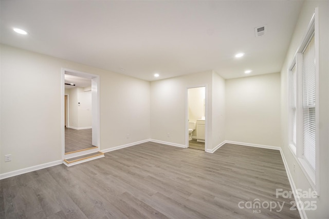 basement featuring baseboards, visible vents, wood finished floors, and recessed lighting