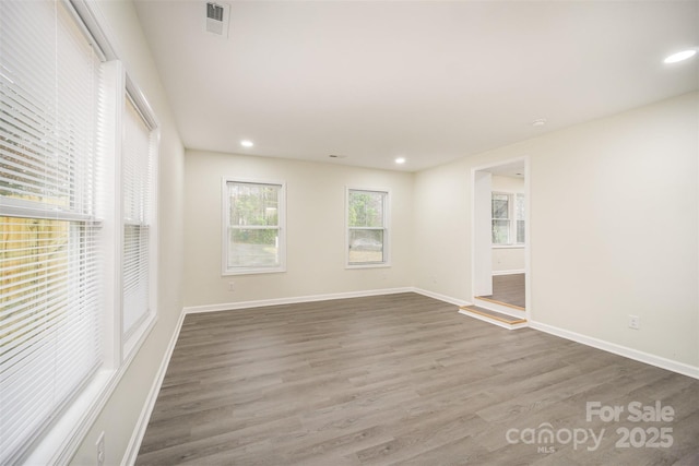 empty room with recessed lighting, visible vents, baseboards, and wood finished floors