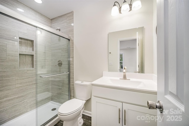 bathroom with a chandelier, a stall shower, vanity, and toilet