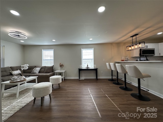 living room with baseboards, dark wood finished floors, visible vents, and recessed lighting