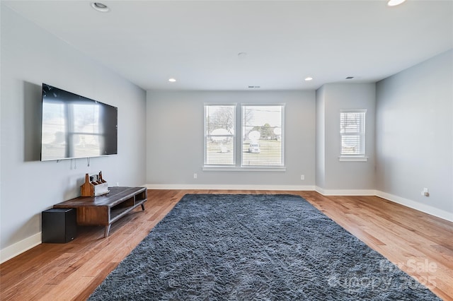 living area featuring recessed lighting, baseboards, and wood finished floors