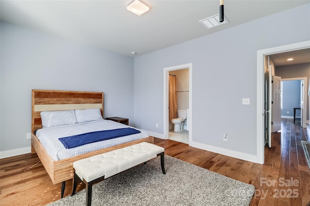 bedroom featuring wood-type flooring, connected bathroom, and baseboards