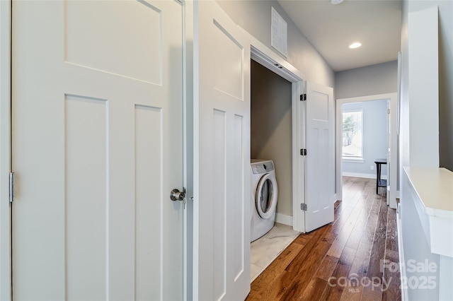 laundry room featuring visible vents, hardwood / wood-style floors, washer / dryer, laundry area, and baseboards