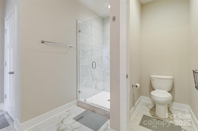 bathroom featuring marble finish floor, toilet, a shower stall, and baseboards