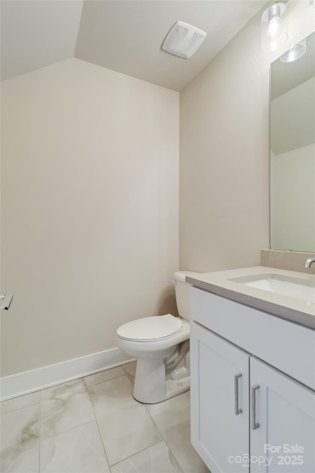 bathroom with baseboards, visible vents, toilet, vaulted ceiling, and vanity