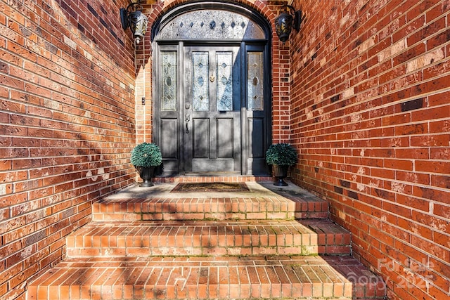 doorway to property with brick siding