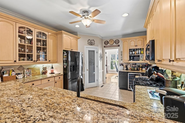 kitchen featuring decorative backsplash, stainless steel microwave, light stone countertops, black refrigerator with ice dispenser, and crown molding