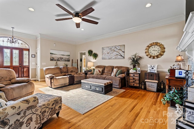 living room featuring ceiling fan with notable chandelier, light wood-type flooring, crown molding, and recessed lighting