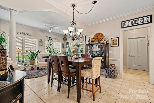 dining space featuring ceiling fan with notable chandelier, ornamental molding, light tile patterned flooring, and decorative columns