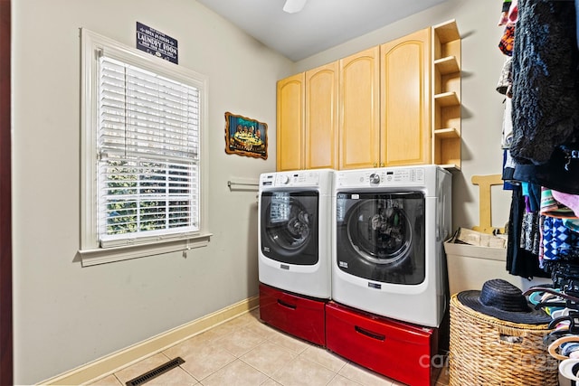 laundry area with light tile patterned floors, visible vents, cabinet space, washing machine and dryer, and baseboards