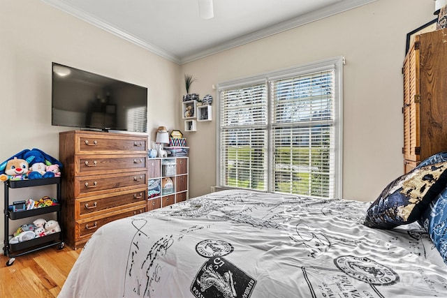 bedroom with a ceiling fan, ornamental molding, and wood finished floors